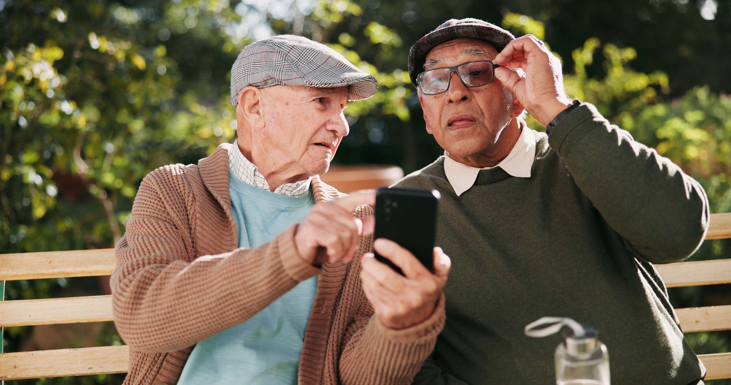 FAQ - Two seniors helping each other use the Spotly app.